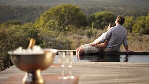 A couple sitting on a wooden deck overlooking a natural landscape. - Kwandwe Great Fish River Lodge (Makhanda)