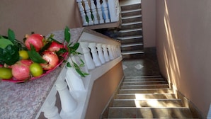 A staircase with a white balustrade, a basket of fruits on a counter, and a tiled floor. - Apartments Moreta (Biograd na Moru)