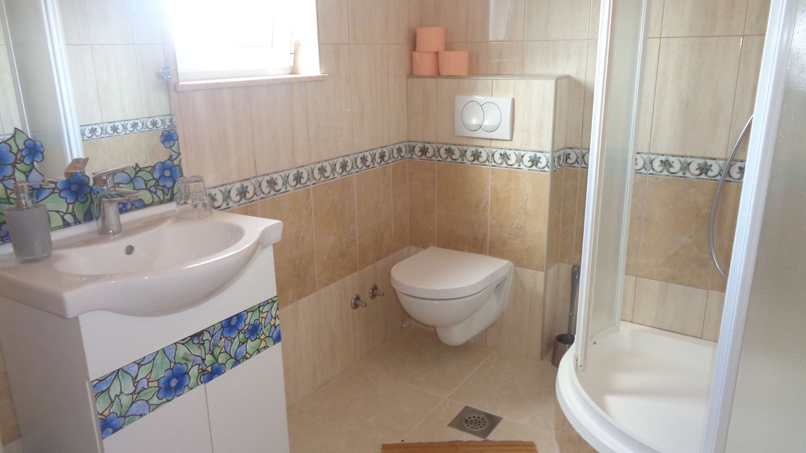 A bathroom with a sink, toilet, and shower.