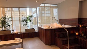 A spa area with a hot tub, wooden benches, and potted plants. - Design Suites Buenos Aires (Buenos Aires)