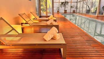 Una piscina techada, sillones reclinables de piscina