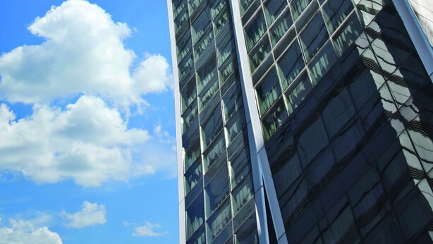 A modern skyscraper with a unique cantilevered section and reflective glass facade. - Design Suites Buenos Aires (Buenos Aires)