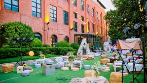 Un espacio para eventos al aire libre con fardos de heno, zonas de estar y una carpa.