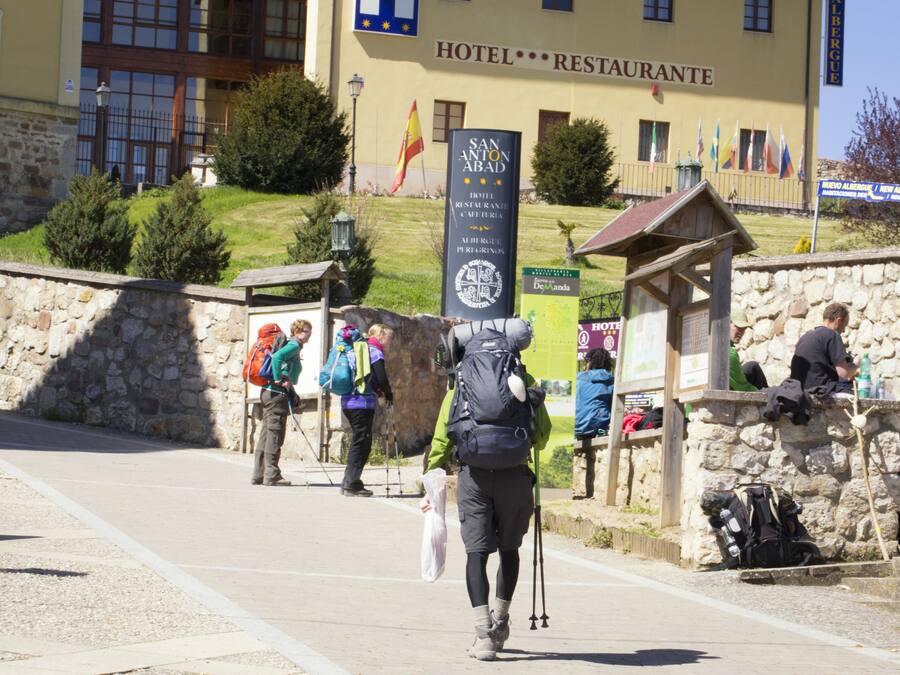 Un muro de piedra con un refugio de madera, un letrero que dice Hotel Restaurant y banderas.
