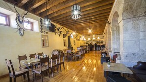 A rustic interior with wooden floors, stone walls, and various antlers and skulls displayed on the walls. - Hotel San Antón Abad (Villafranca Montes de Oca)