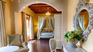 A bedroom with a bed, a chair, a table, and a mirror. - Hotel San Antón Abad (Villafranca Montes de Oca)
