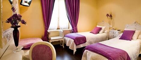 A hotel room with two beds, a desk, and a chair.