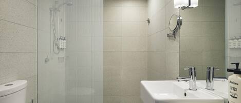 A modern bathroom with a toilet, sink, and shower.