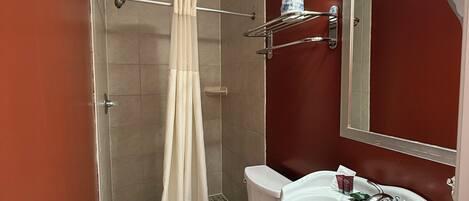 Un bagno con doccia, WC e lavandino.