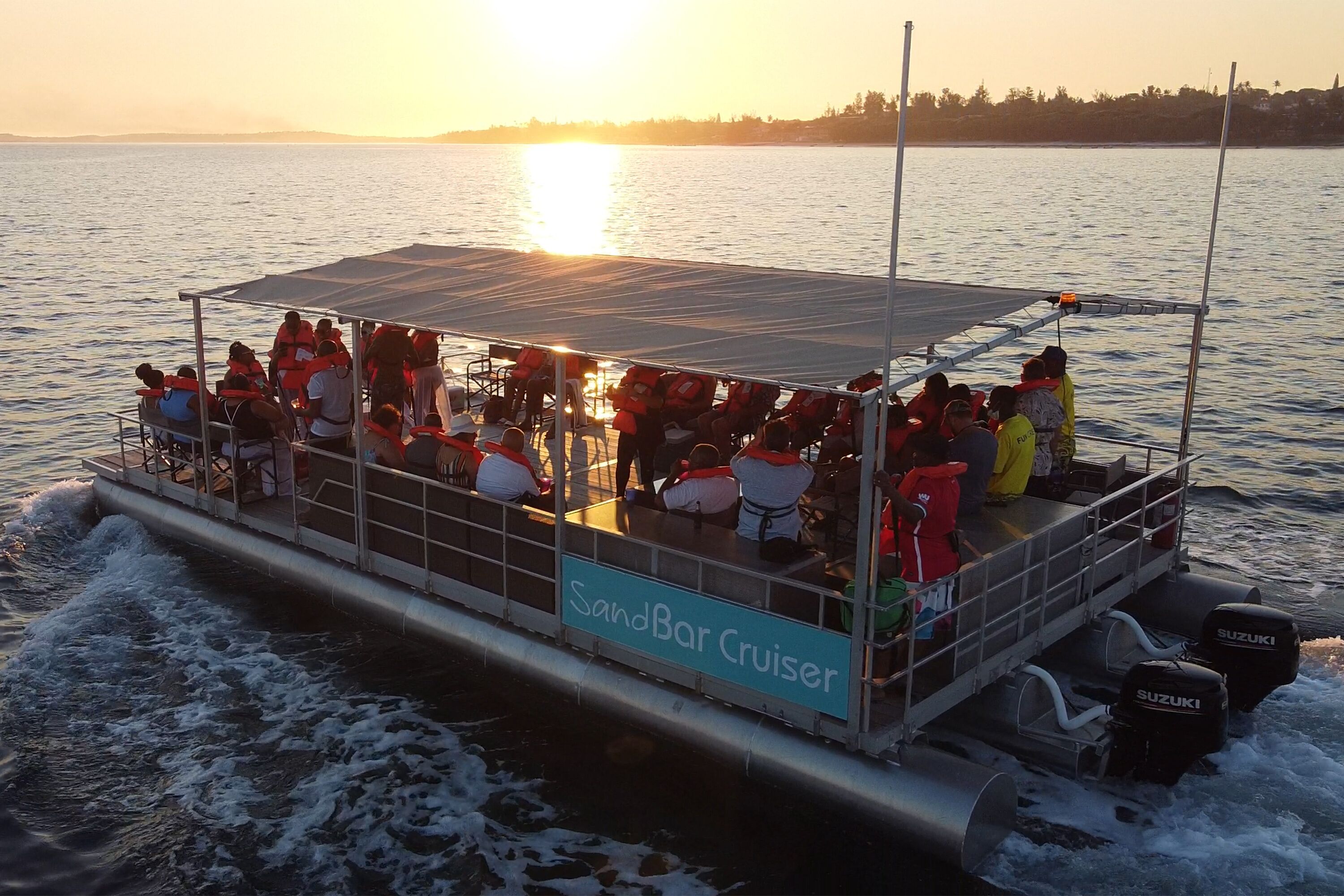 A cruise ship with a covered deck and multiple seating areas, labeled "SandBar Cruiser."
