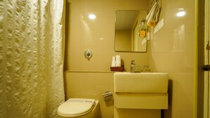 Un bagno con il water, un lavandino e uno specchio.
