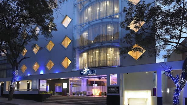 Un hôtel moderne doté d’une façade en verre, de plusieurs étages et d’une entrée imposante.