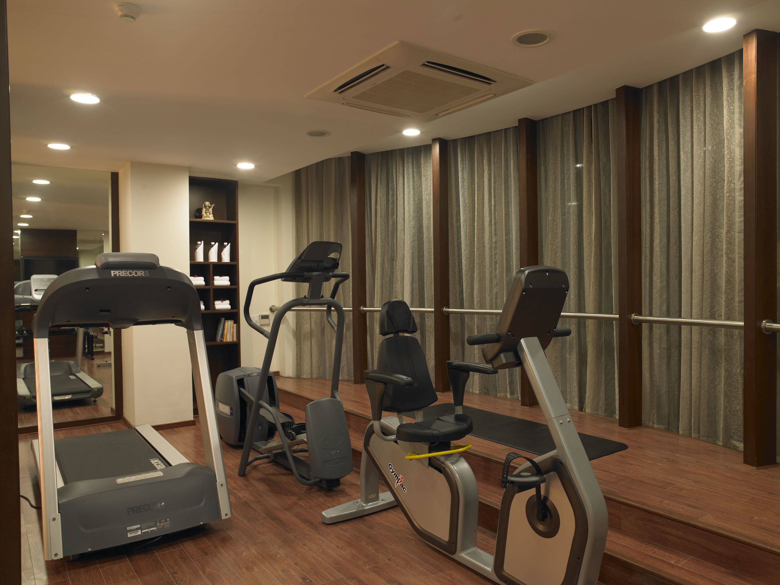 A gym with treadmills, elliptical machines, and a stationary bike.