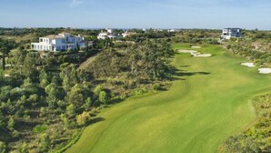 A golf course with multiple houses in the background. - Hotel Apolo (Vila Real Santo Antonio)