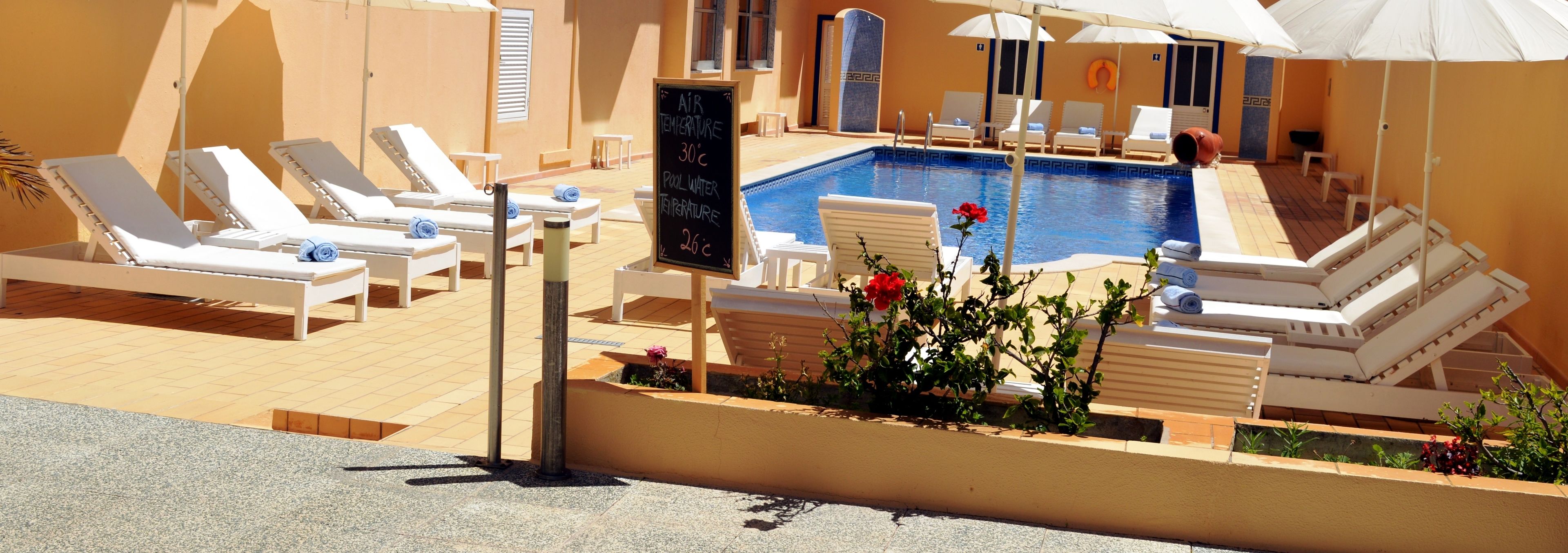 outdoor pool, open 9:00 am to 8:00 pm, pool umbrellas, pool loungers
