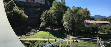 A swimming pool with a view of a hillside with buildings and trees.