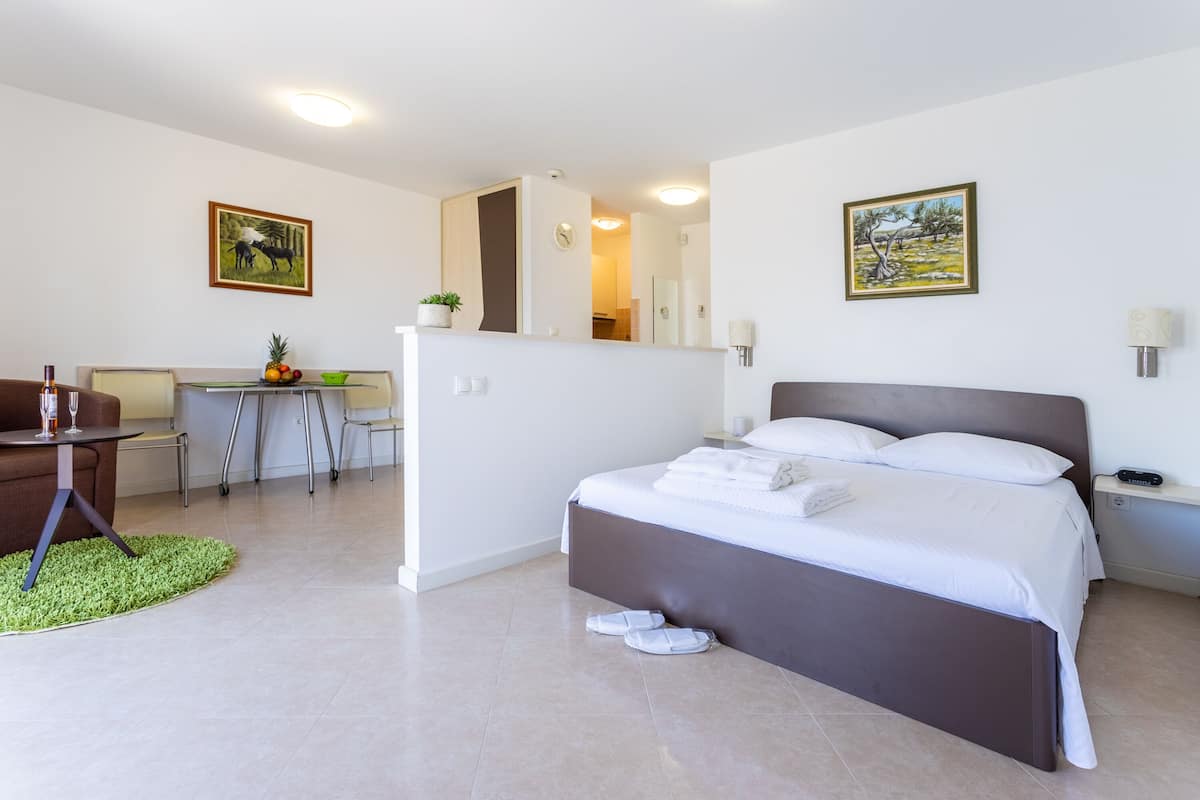 A modern hotel room with a bed, a desk, and a chair.