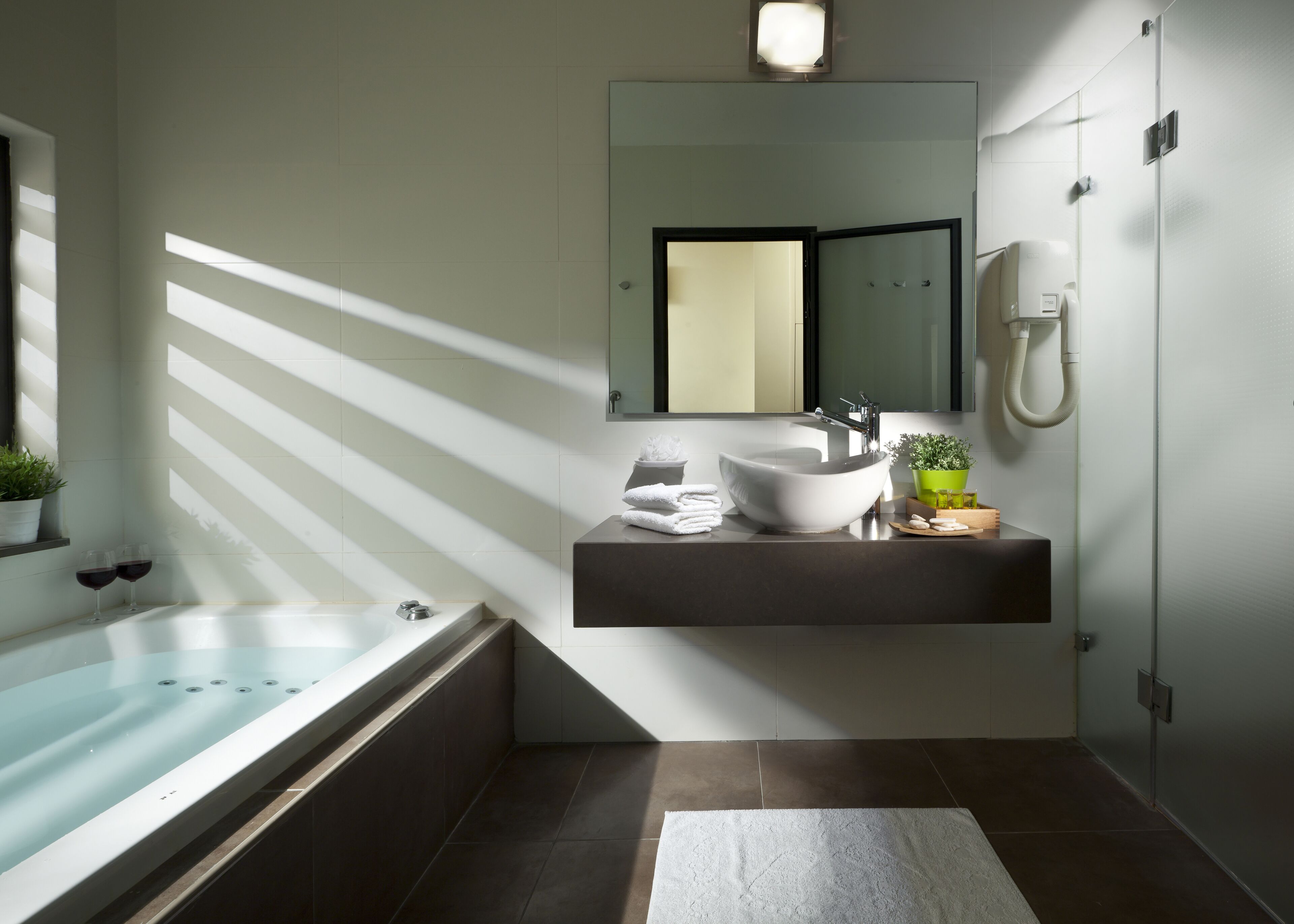 A modern bathroom with a freestanding bathtub, a vessel sink, and a large mirror above the sink.