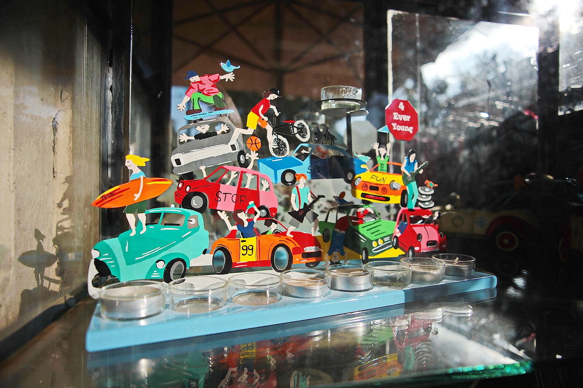 Une collection colorée de voitures miniatures et de figurines exposée sur une étagère.