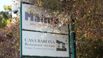 Letrero del Restaurante CASA BARONA con una ilustración de una casa y texto que describe su cocina campestre única.