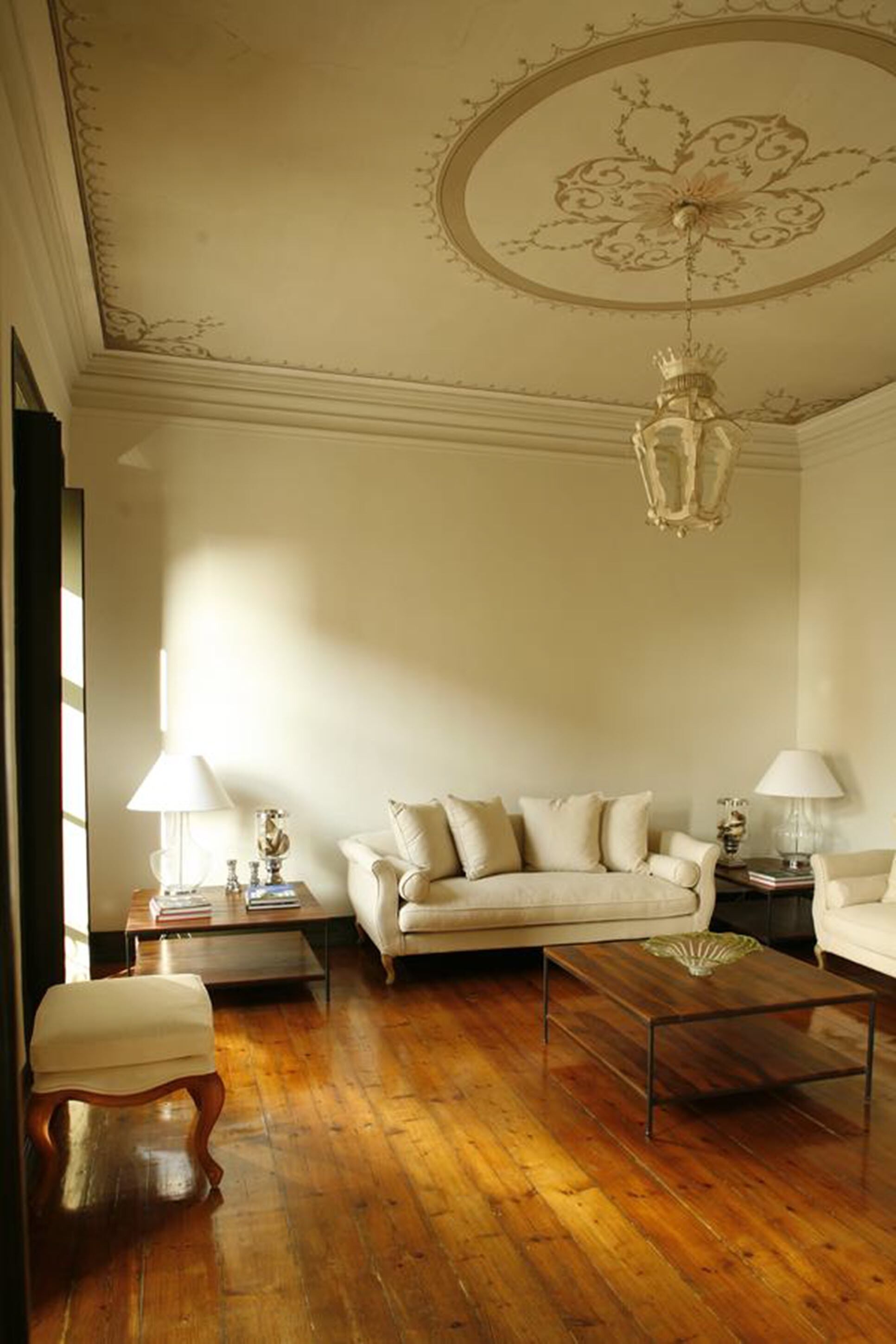 Una sala de estar con sofá, mesa de centro y lámparas.
