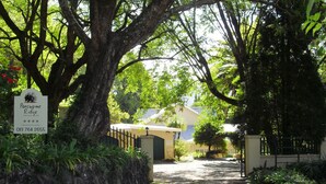 A pathway leading to a building with a sign indicating 'Porcupine Ridge' and a contact number. - Porcupine Ridge Guest House (Sabie)