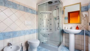 Un bagno con doccia vetrata, lavandino a piedistallo e WC.