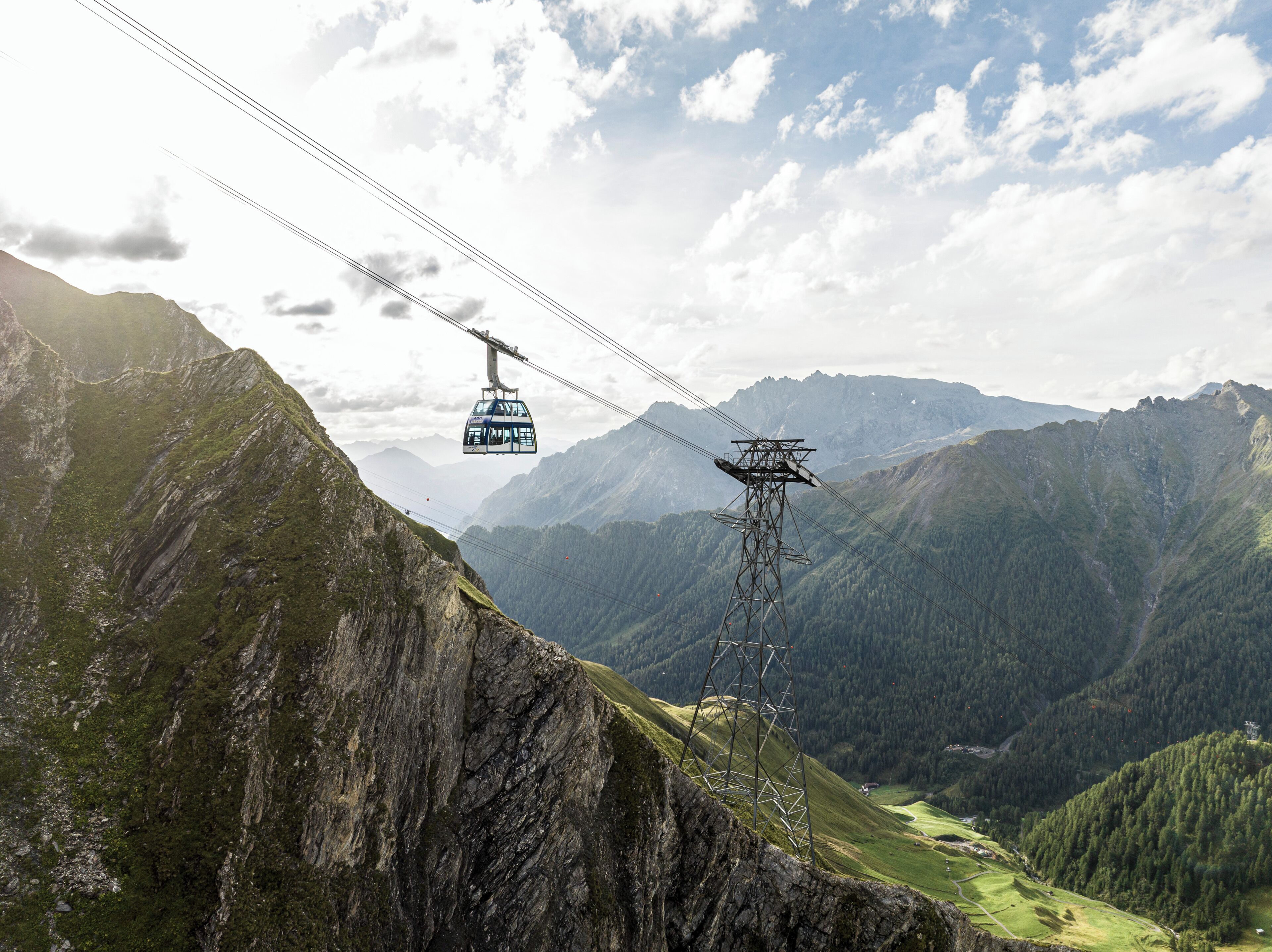 Eine Seilbahn vor einer Berglandschaft.
