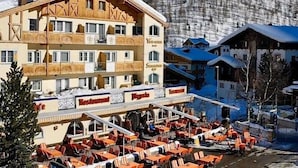 A hotel with a restaurant and outdoor seating area, surrounded by snow-covered mountains. - Vitalhotel Samnaunerhof  (Samnaun)