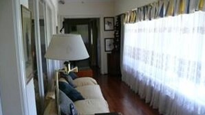 Una sala de estar con un sofá, una lámpara y una mesa con un libro.