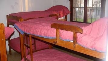 Habitación con literas, ropa de cama rosa y estructura de madera.