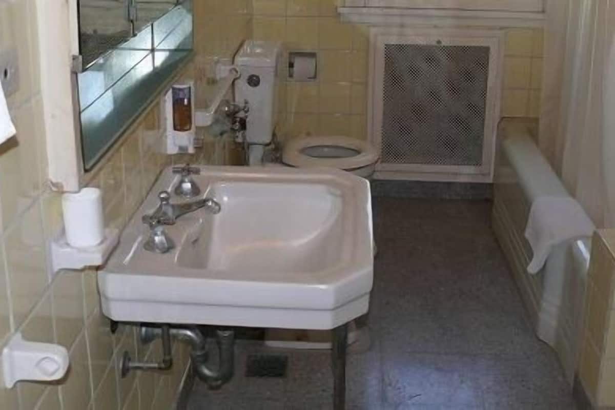 Un baño pequeño con lavamanos, inodoro y zona de ducha.