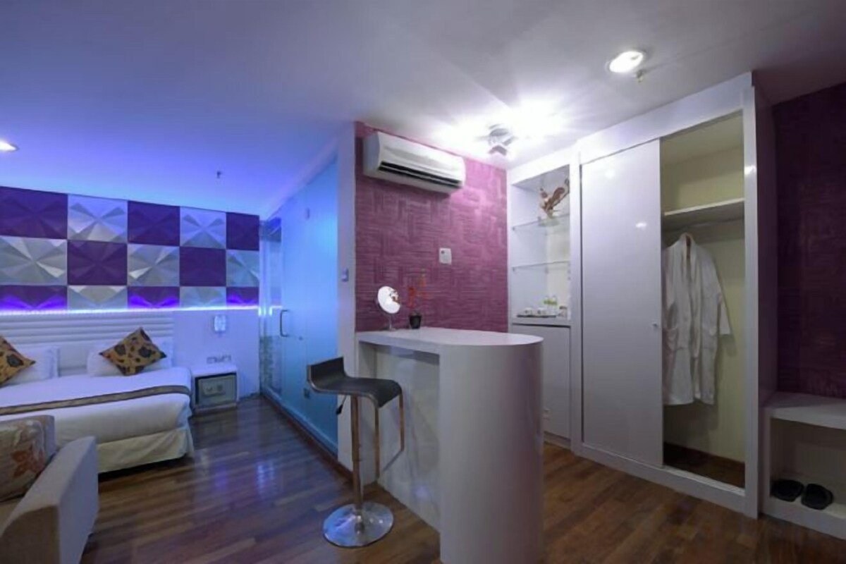A modern bedroom with a bed, bedside table, and a wardrobe.