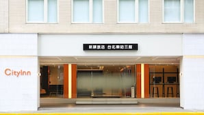 A hotel entrance with a sign indicating it's a new hotel at a train station.