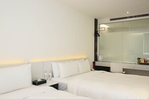Een moderne hotelkamer met een groot bed, nachtkastjes, een spiegel en een zithoek.