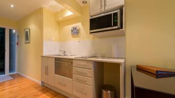 Una cocina moderna con microondas, horno y lavamanos.