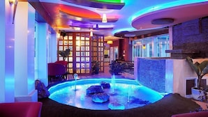 A lobby with a pool, red seating, and a reception desk. - Thi Thao Gardenia Hotel (Xuan Huong - Da Lat)