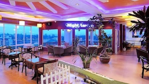 A restaurant with a view of the cityscape, featuring tables and chairs, potted plants, and a white picket fence. - Thi Thao Gardenia Hotel (Xuan Huong - Da Lat)