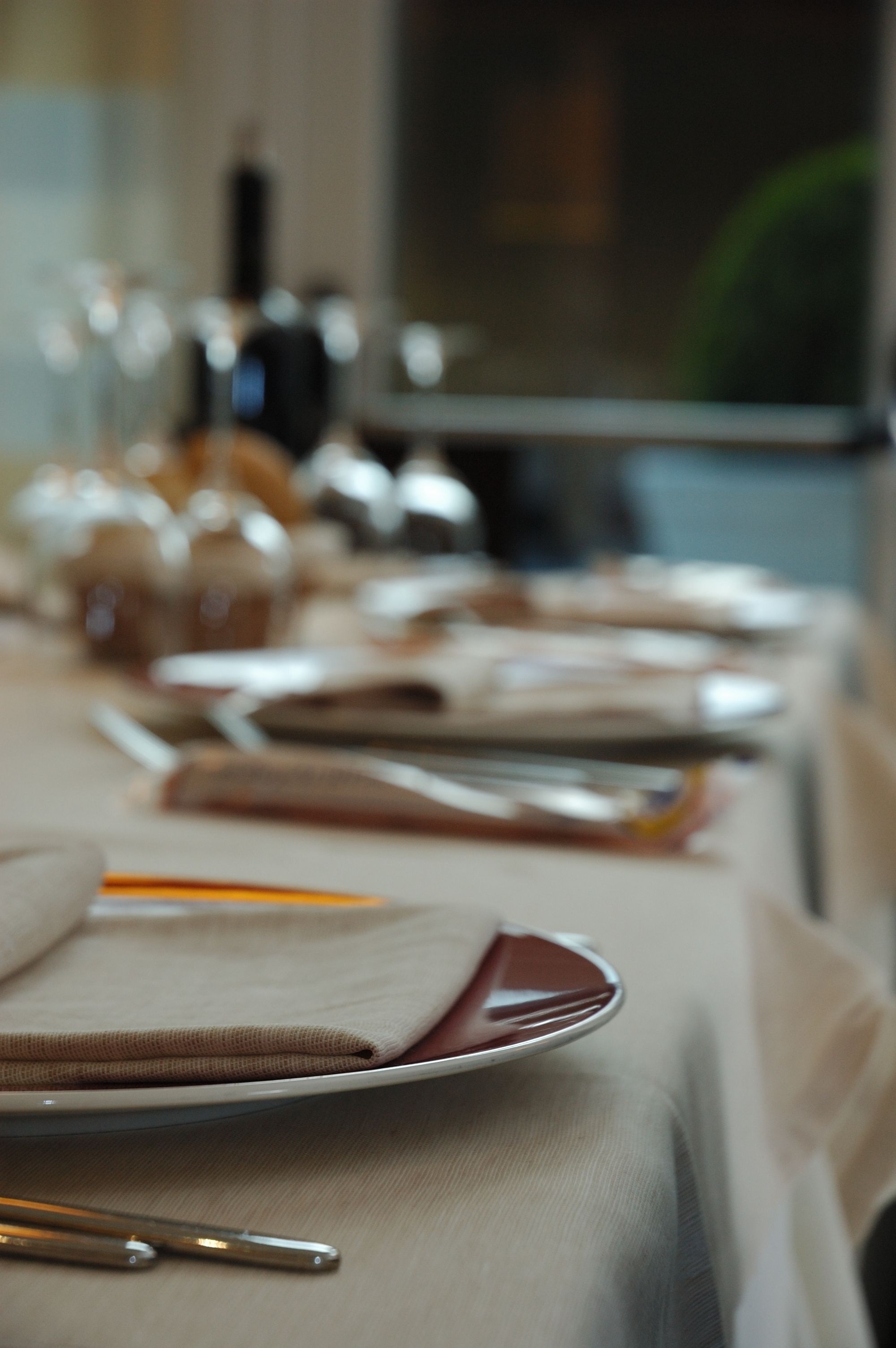 A dining table set with plates, cutlery, and glasses, indicating a formal dining arrangement.