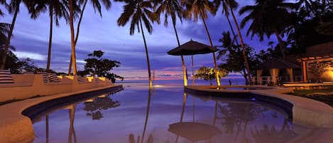 Una piscina al aire libre, sombrillas, tumbonas