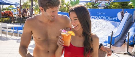 Una pareja en un resort con un parque acuático al fondo.