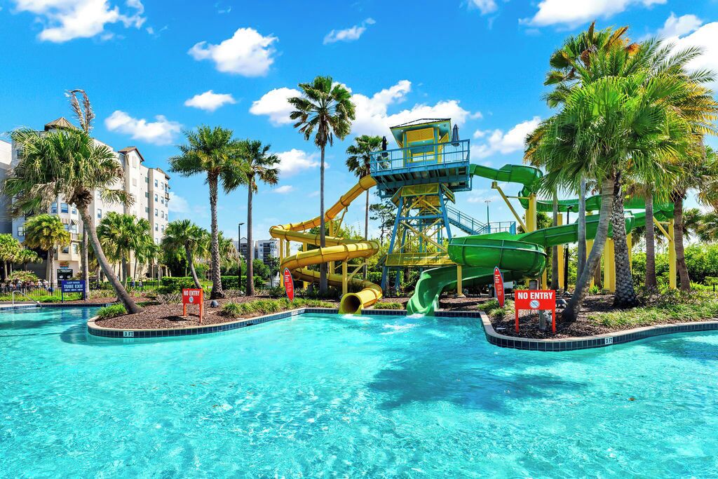 A swimming pool with multiple water slides and a lifeguard tower.