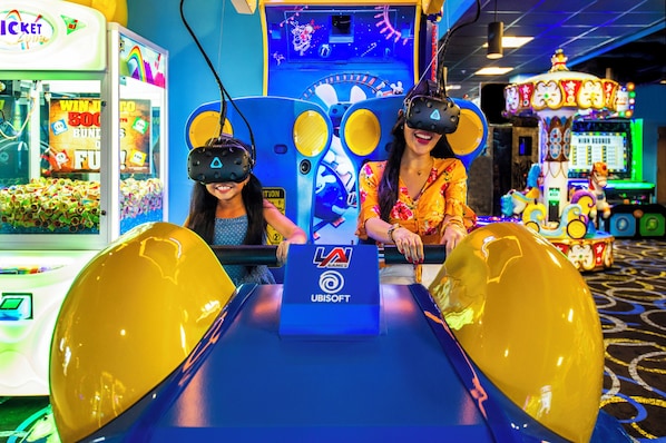 An indoor amusement arcade with VR gaming stations and various arcade games. - The Grove Resort & Water Park Orlando (Winter Garden)