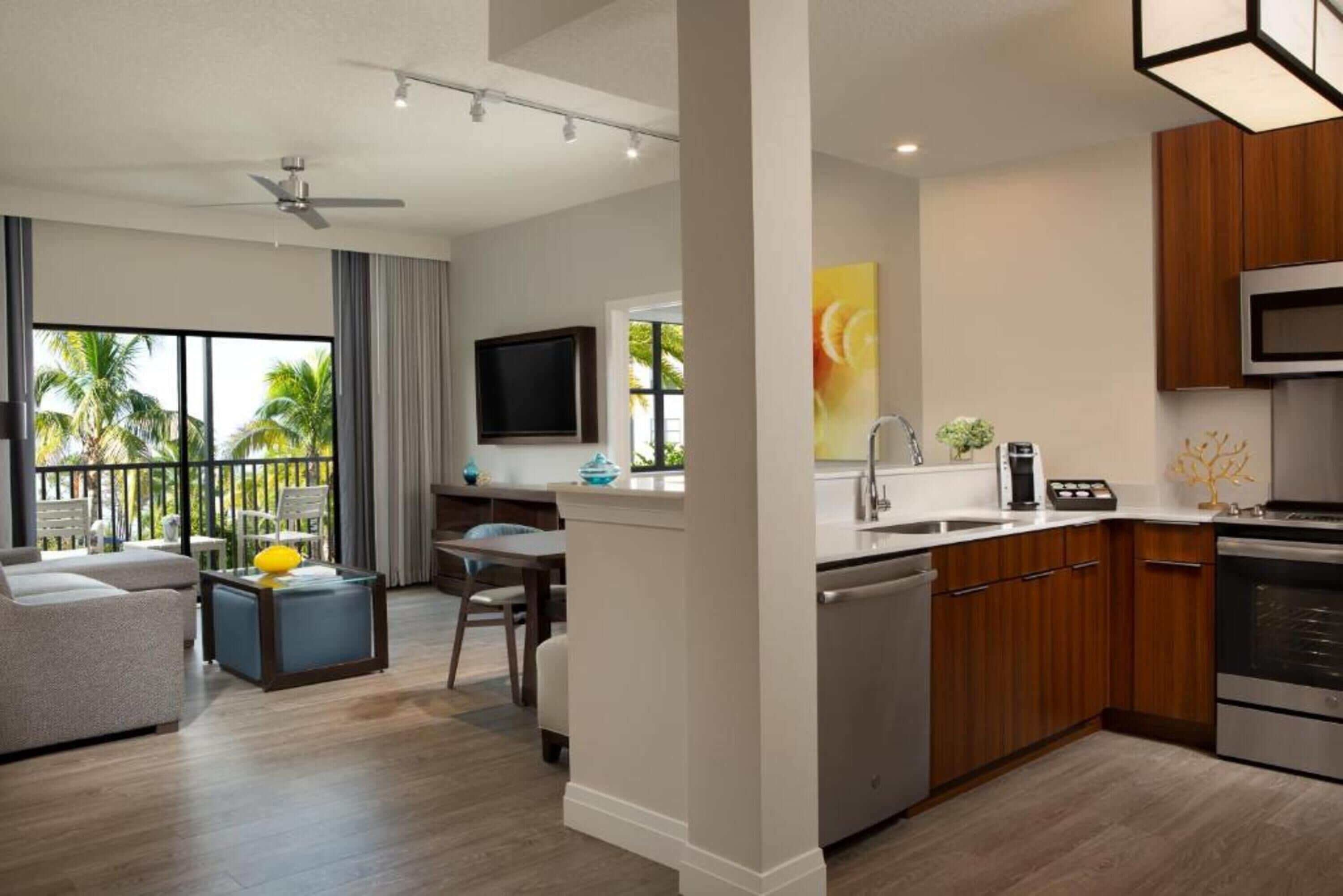 A modern apartment with a living room, dining area, and kitchen.