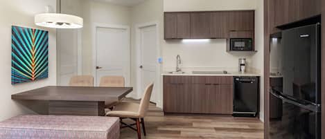 A modern kitchen with wooden cabinets, a built-in microwave, and a refrigerator.