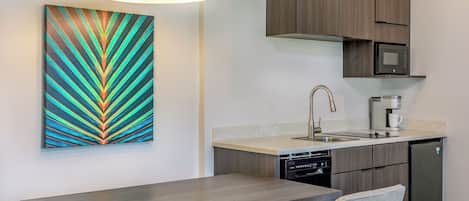 A modern kitchen with a built-in microwave, coffee maker, and dishwasher.