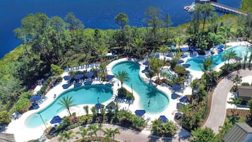 Un resort con múltiples piscinas, zonas de descanso y vista al mar.
