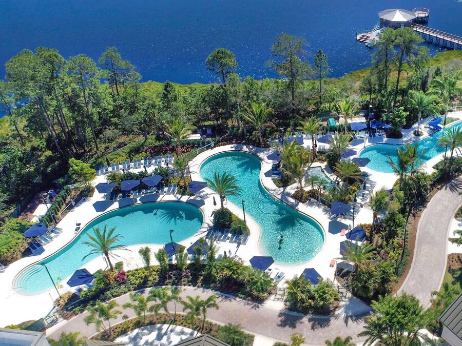 A resort with multiple swimming pools, lounge areas, and a view of the sea.