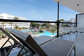 Un balcone con vista su una piscina e gli edifici circostanti.