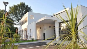 Un edificio moderno, de color blanco, con techo plano y ventanas amplias.